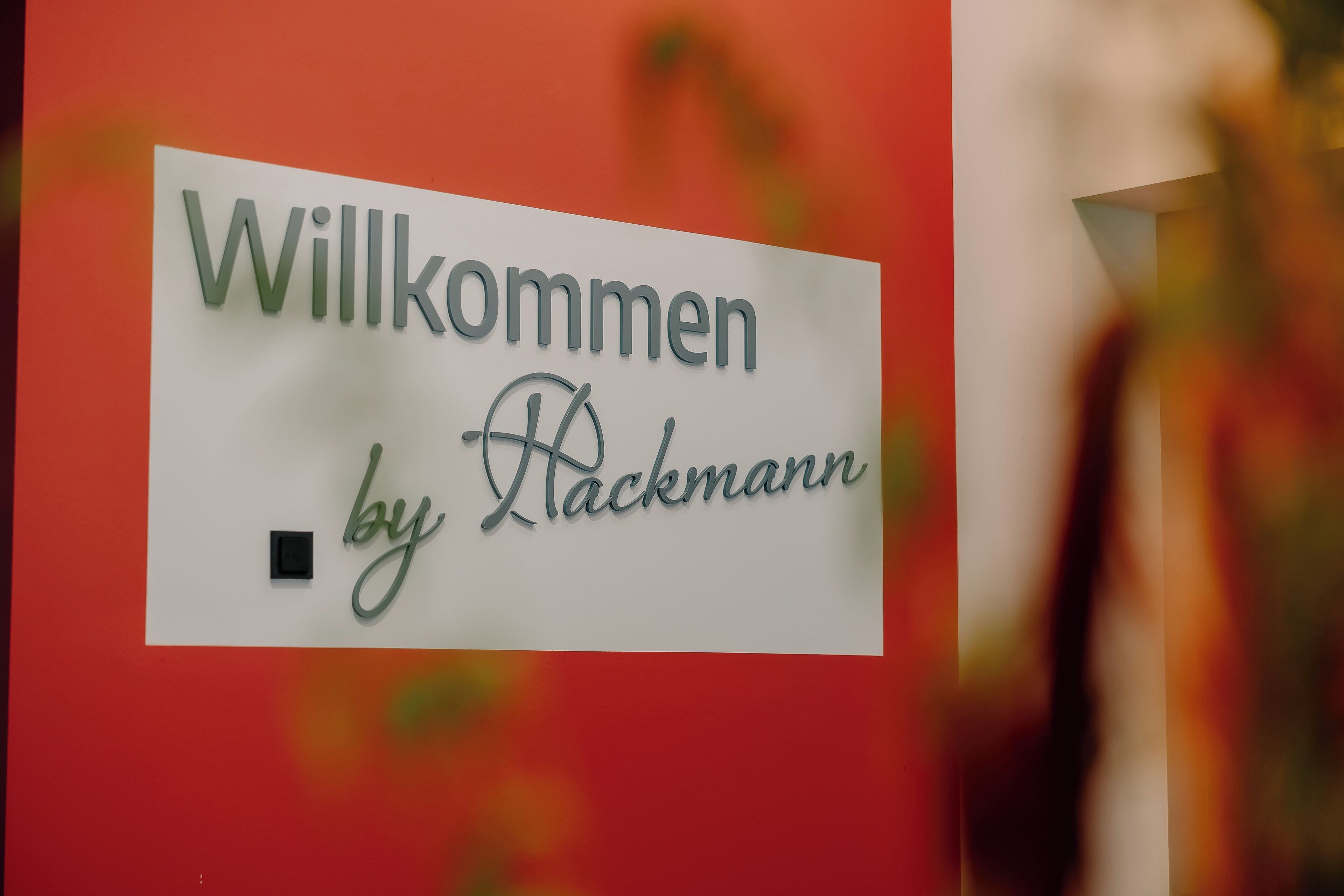 En velkomstskilt med teksten 'Willkommen by Rackmann'.