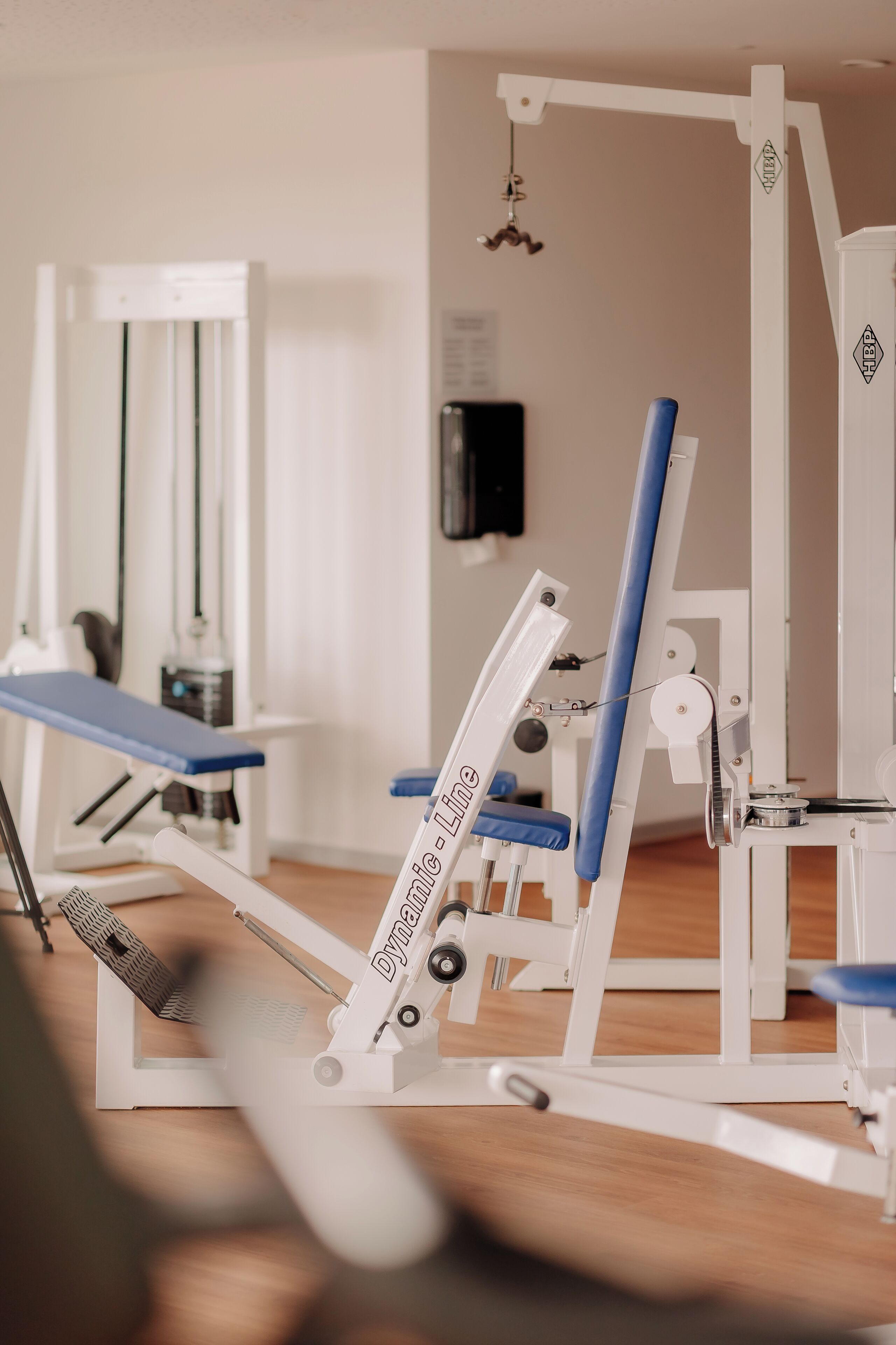 Un gimnasio con equipo de ejercicio, incluyendo una banca y una máquina de prensa de piernas.