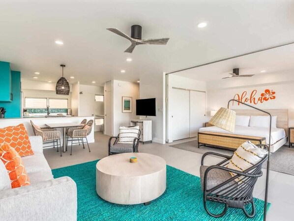A modern living room with a round coffee table, a sofa, and a dining area with chairs. - Waikīkī Shore #608 - Beautiful 1 Bedroom Ocean View w/ a Modern Full Kitchen (HONOLULU)