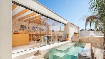 Una piscina al aire libre, sombrillas, tumbonas