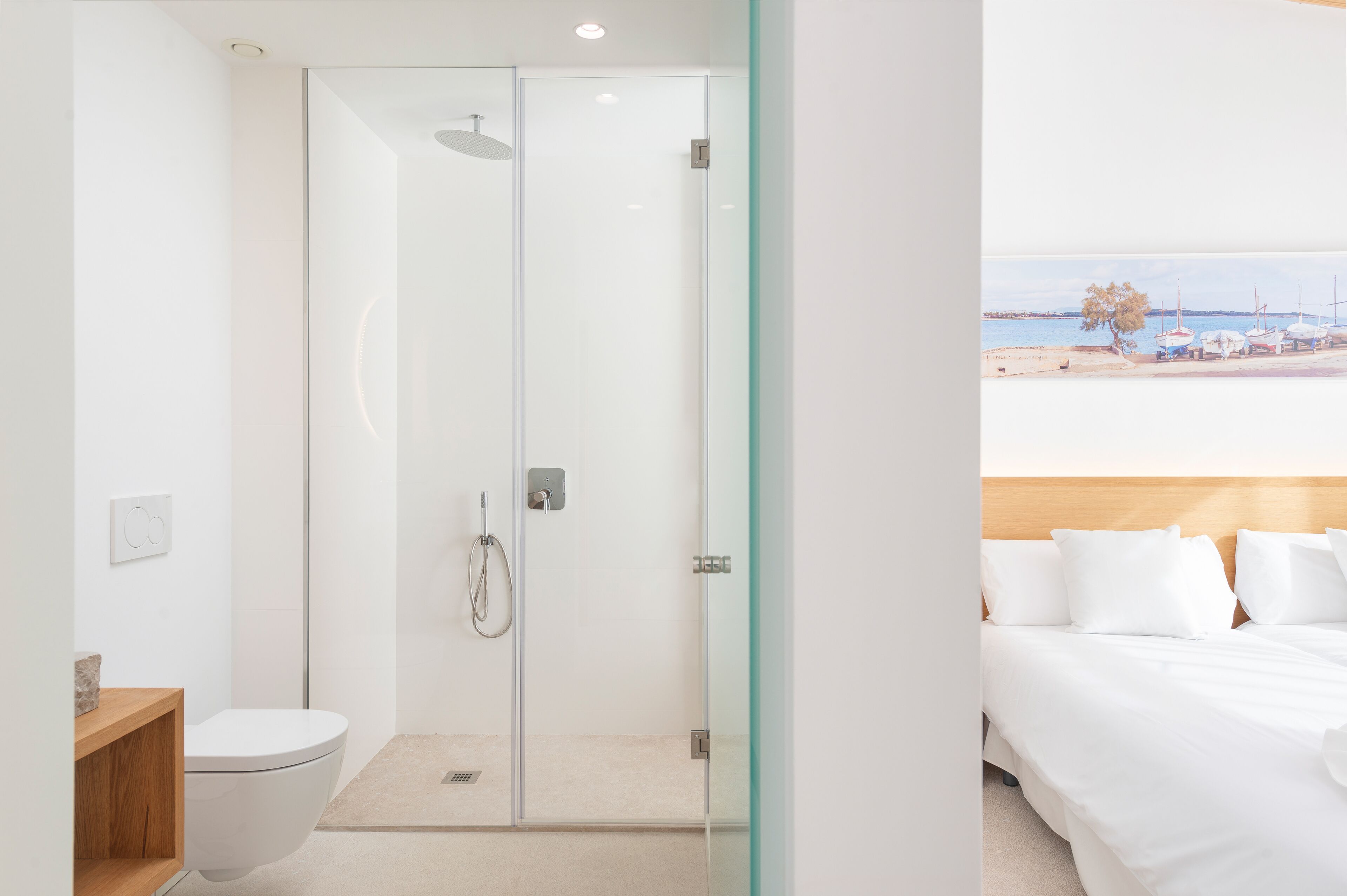 Un baño moderno con cabina de ducha de vidrio, inodoro y tocador de madera.