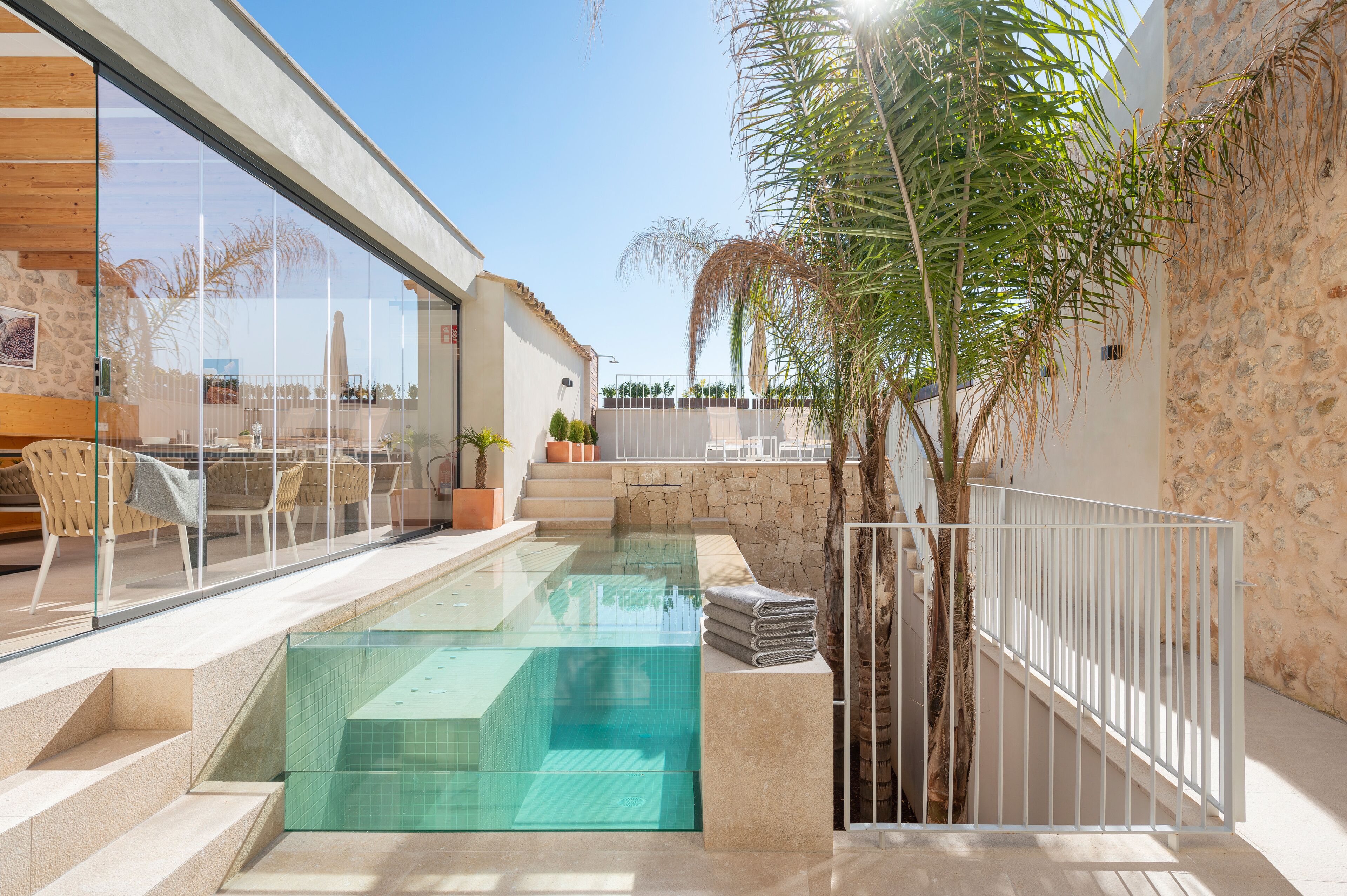 Una piscina al aire libre, sombrillas, sillones reclinables de piscina