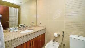 A bathroom with two sinks, a mirror, a toilet, and a shower. - Cozy Studio - Goldcrest Executives JLT - NLN (Dubai)