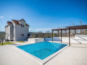 A modern house with a swimming pool, a pergola, and a view of the countryside. - Villa Camellia (Obrovac)