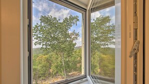 A window with a view of a forested landscape. - 'The Glabin’: Garrison Gem w/ Hot Tub & Fire Pit (Garrison)