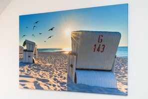 A beach chair with the number G 143, a white beach chair, and a white beach umbrella.
