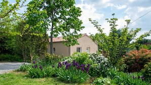 A house with a garden in front, surrounded by trees and various plants. - GÎte Les Cerisiers, 3 stars (Ailhon)