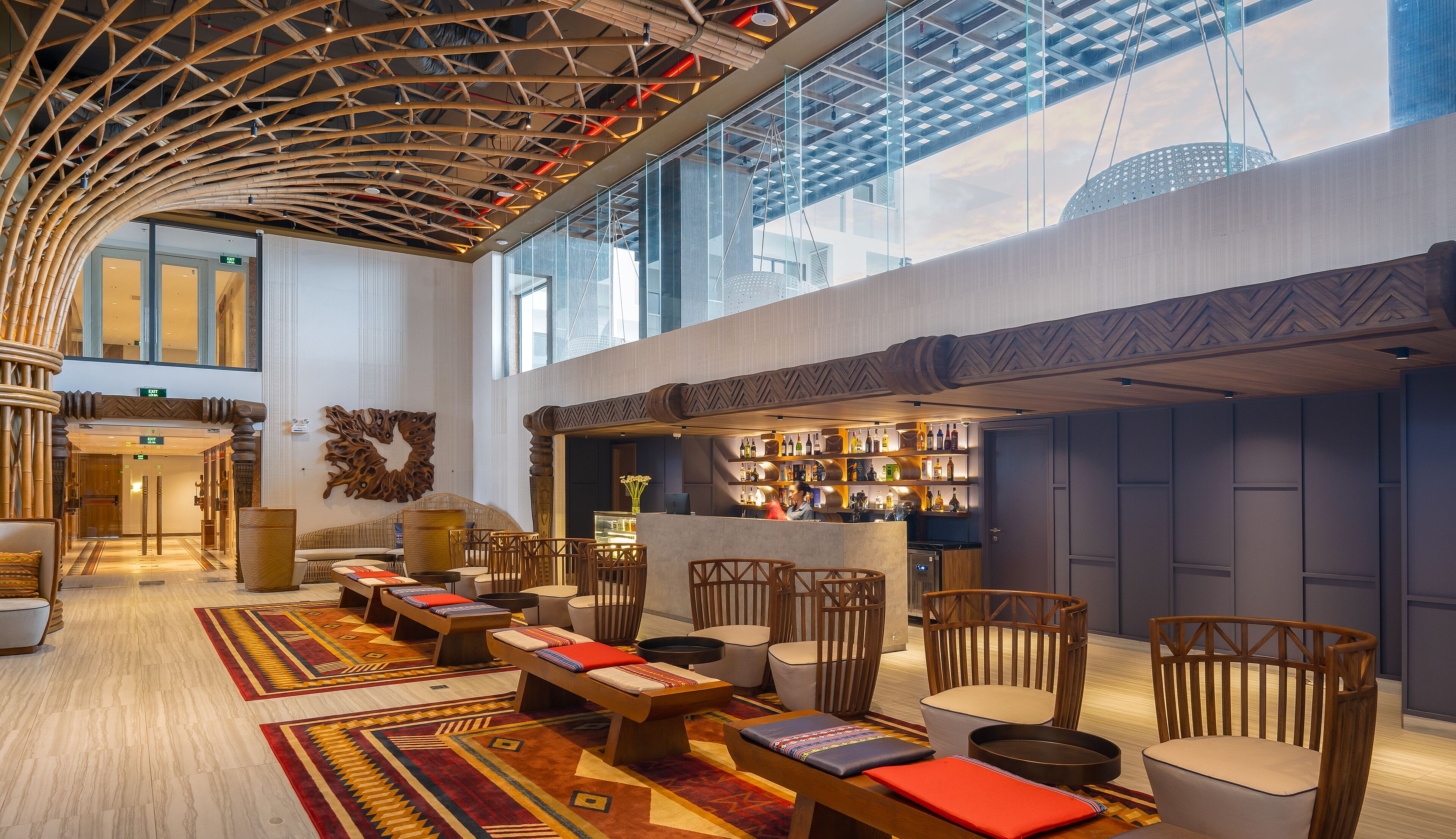 A spacious lobby with a high ceiling, a bar area, and seating arrangements.