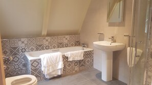 Ein Badezimmer mit einer Badewanne, einem Waschbecken und einer Toilette.