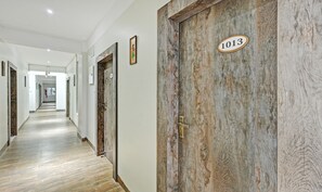 A hallway with wooden doors, each marked with a number. - Treebo Sidhartha Elite (Bhubaneshwar)