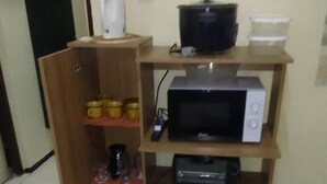 A kitchen with a microwave, a coffee maker, and a toaster on a wooden shelf unit. - 3 Bed House - Sleeps 4 - Parking - Enclosed Garden (Paramaribo)