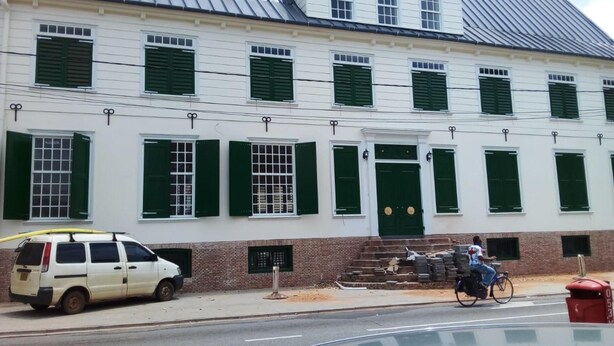 A two-story building with green shutters and a brick base. - 3 Bed House - Sleeps 4 - Parking - Enclosed Garden (Paramaribo)