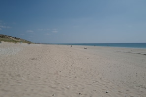 A wide sandy beach with a clear sky.