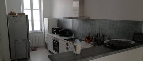 Een moderne keuken met een koelkast, fornuis en aanrecht.