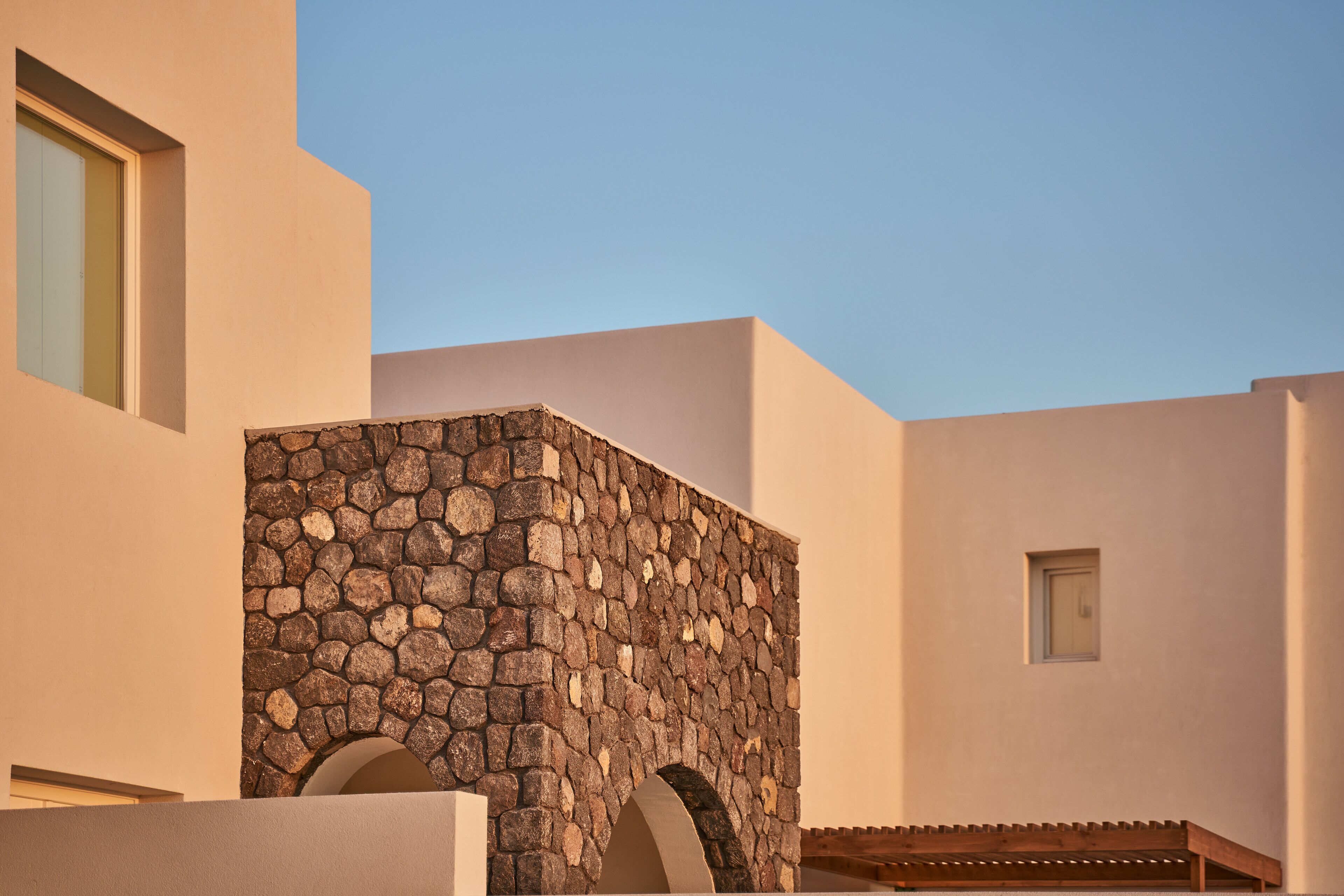 A modern building with a stone facade and arched openings.