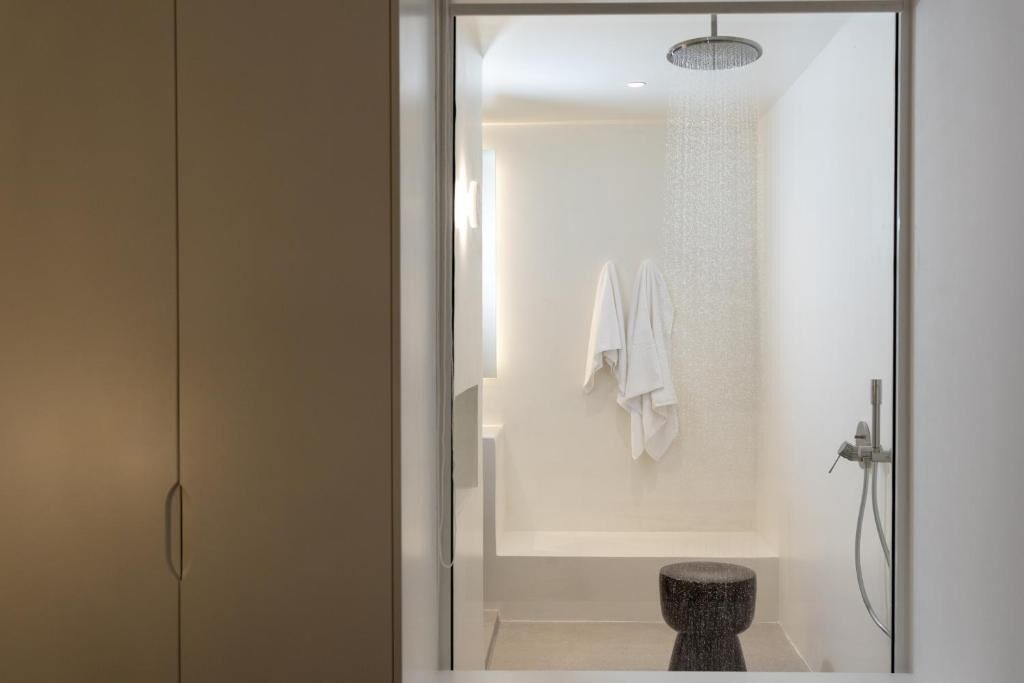 Un baño moderno con ducha, inodoro y perchero para toallas.