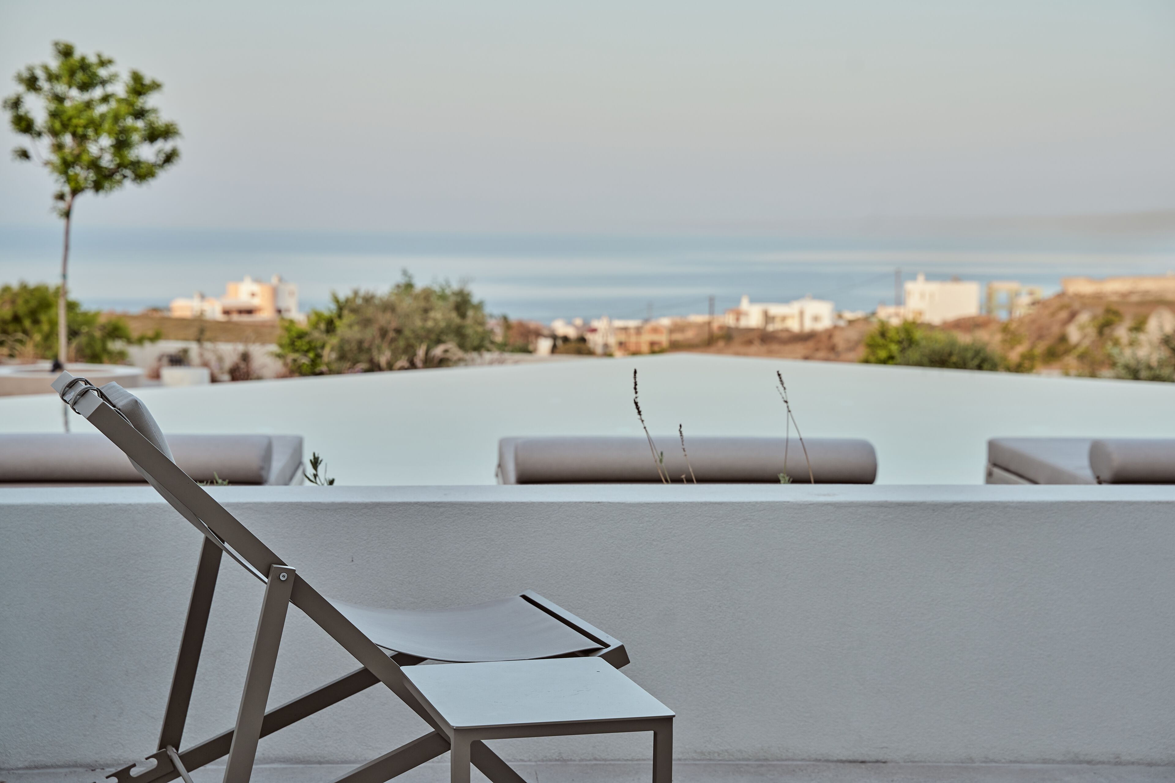 Terraza en la azotea con una sola silla de salón y vistas a la costa.