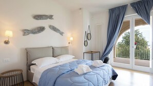 A bedroom with a bed, bedside lamps, a small table, and a view of the outdoors. - Don Onofrio Holiday House - app.to Fiammetta (Monopoli)