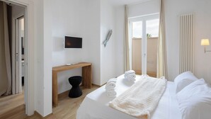 A hotel room with a bed, a desk, a television, and a view of the outdoors. - Don Onofrio Holiday House - app.to Domitilla (Monopoli)