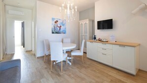 A modern kitchen with white cabinets, a wooden countertop, and a chandelier. - Don Onofrio Holiday House - app.to Domitilla (Monopoli)
