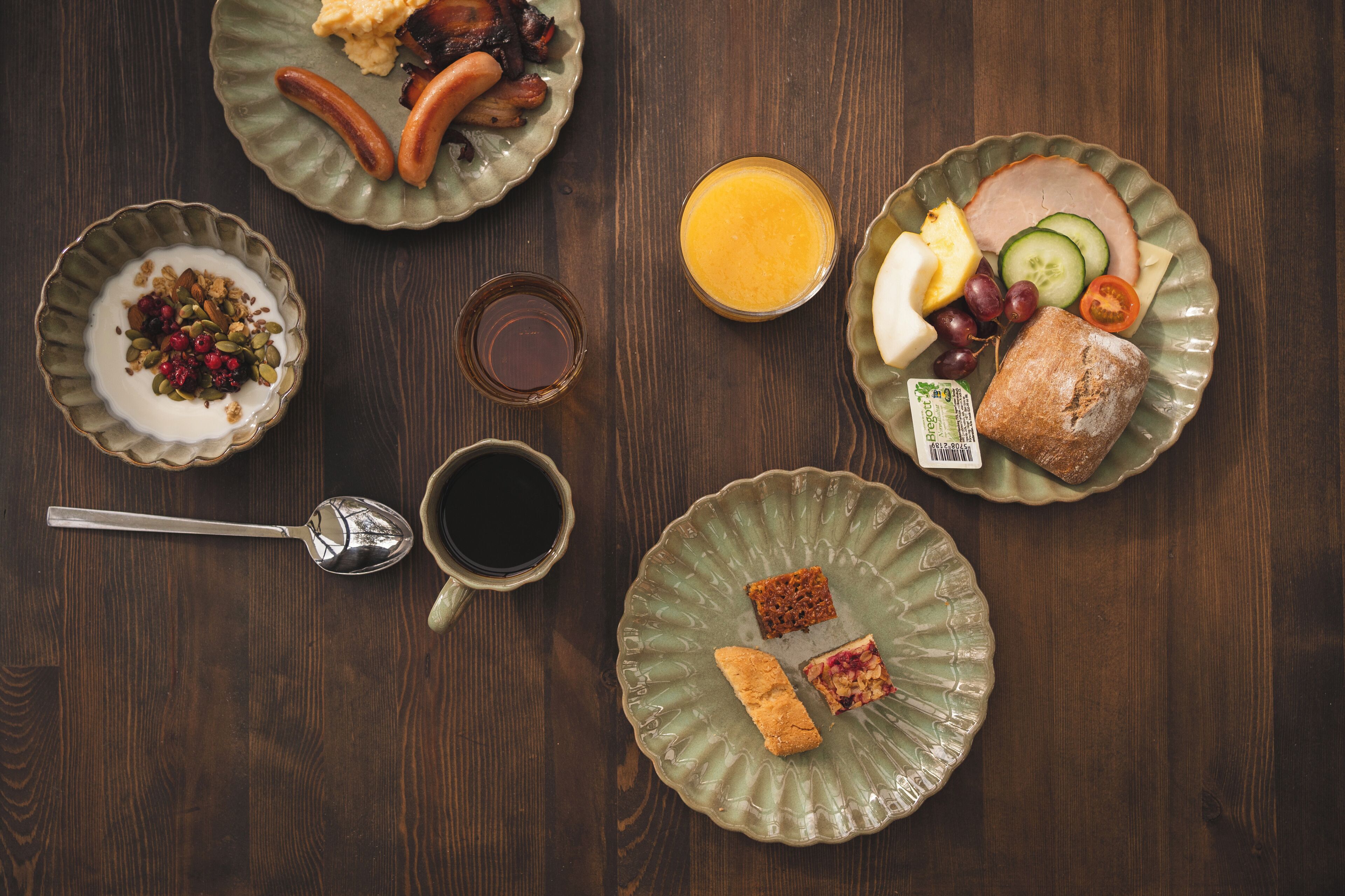 Una mesa de desayuno con platos de comida, una taza y un vaso de jugo.