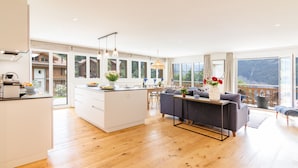 A spacious kitchen with a central island, large windows, and a view of the outdoors. - Chalet Alpenheim 1 (Lauterbrunnen)