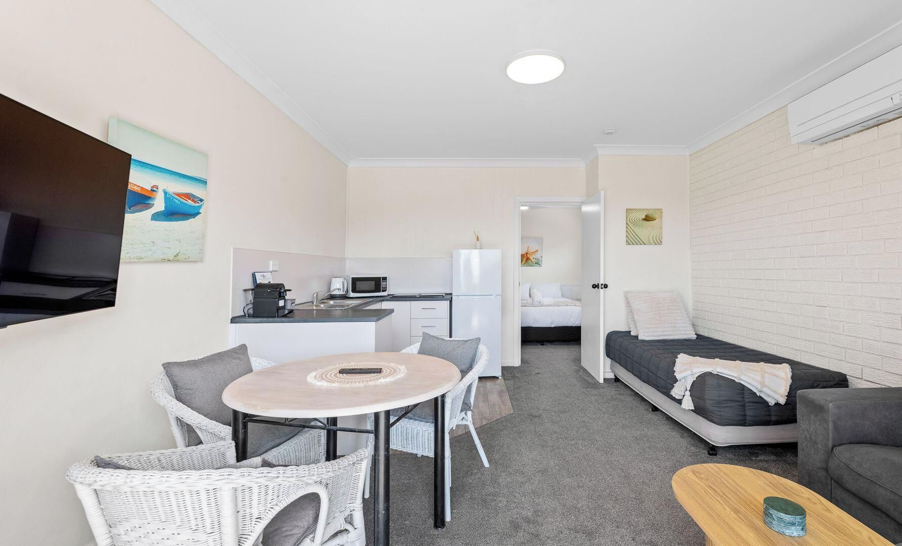 A compact living space with a kitchenette, a dining area, and a sleeping area.