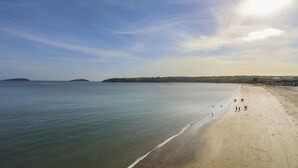 A beach with a clear sky and calm sea. - Bryn Meillion (Pwllheli)