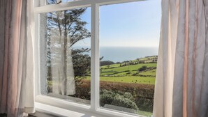 A window with a view of a green landscape and trees. - Bryn Meillion (Pwllheli)
