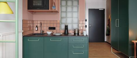 Una cocina con microondas, fregadero y armarios.