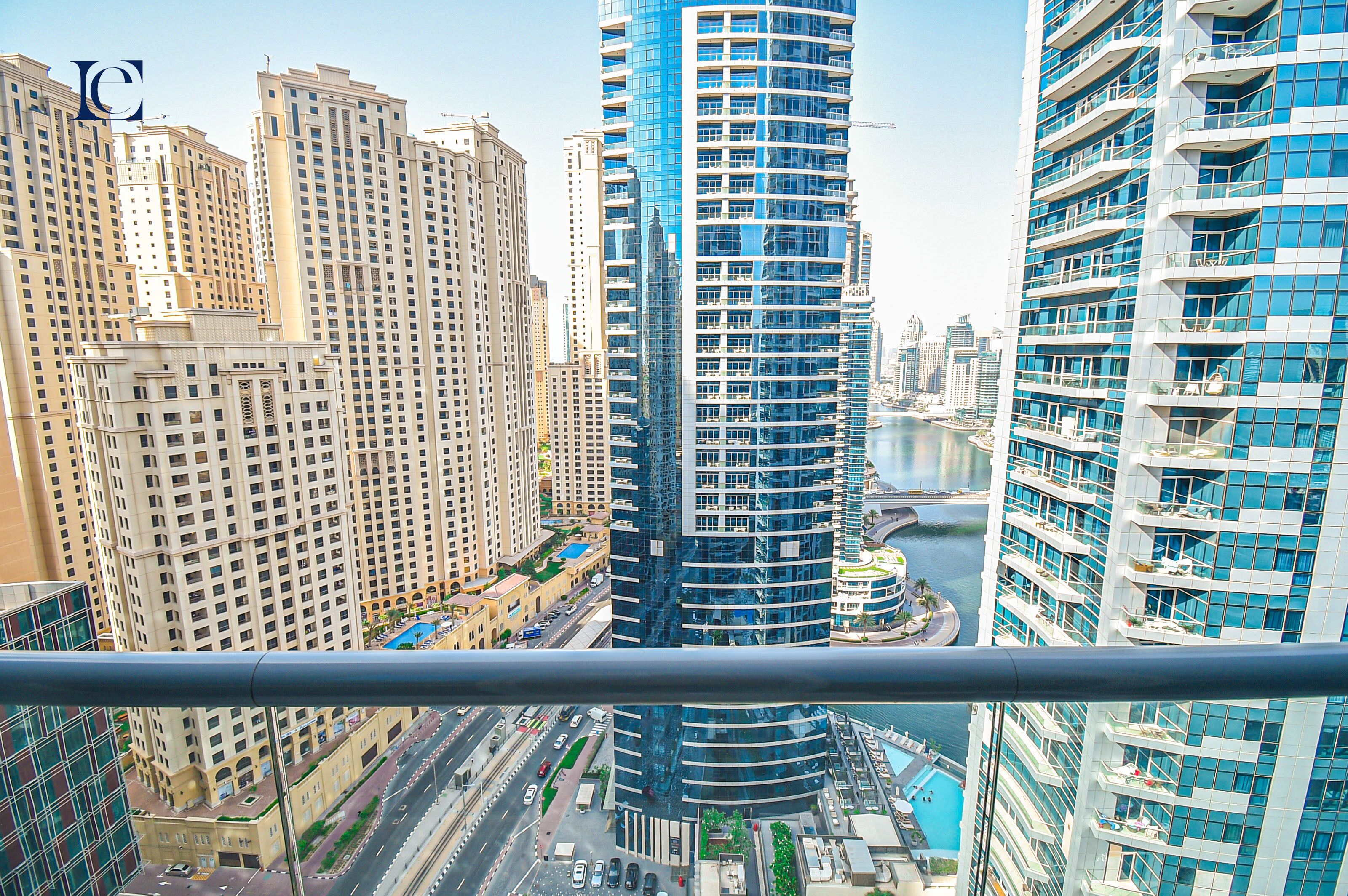 A high-rise building with a curved facade, surrounded by other tall residential buildings.