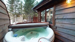 A wooden cabin with a hot tub in the corner. - Pet-Friendly, 5-Star Home, Private Hot Tub, 2-Car Garage, Walk to The Village (Mammoth Lakes)