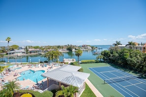 Ein Resort mit Schwimmbad, Tennisplatz und Blick auf einen Hafen und Wasser.