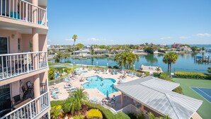 A hotel with a pool area, outdoor seating, and a view of the water. - Gorgeous Bay Views | Shore Retreat (St. Pete Beach)