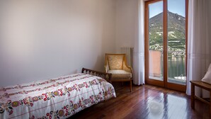 Ein Schlafzimmer mit Bett, Stuhl und Balkon mit Bergblick.