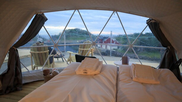 A cozy tent with a bed, two chairs, and a table. - Enjoy Lofoten Glamping (Vestvågøy)