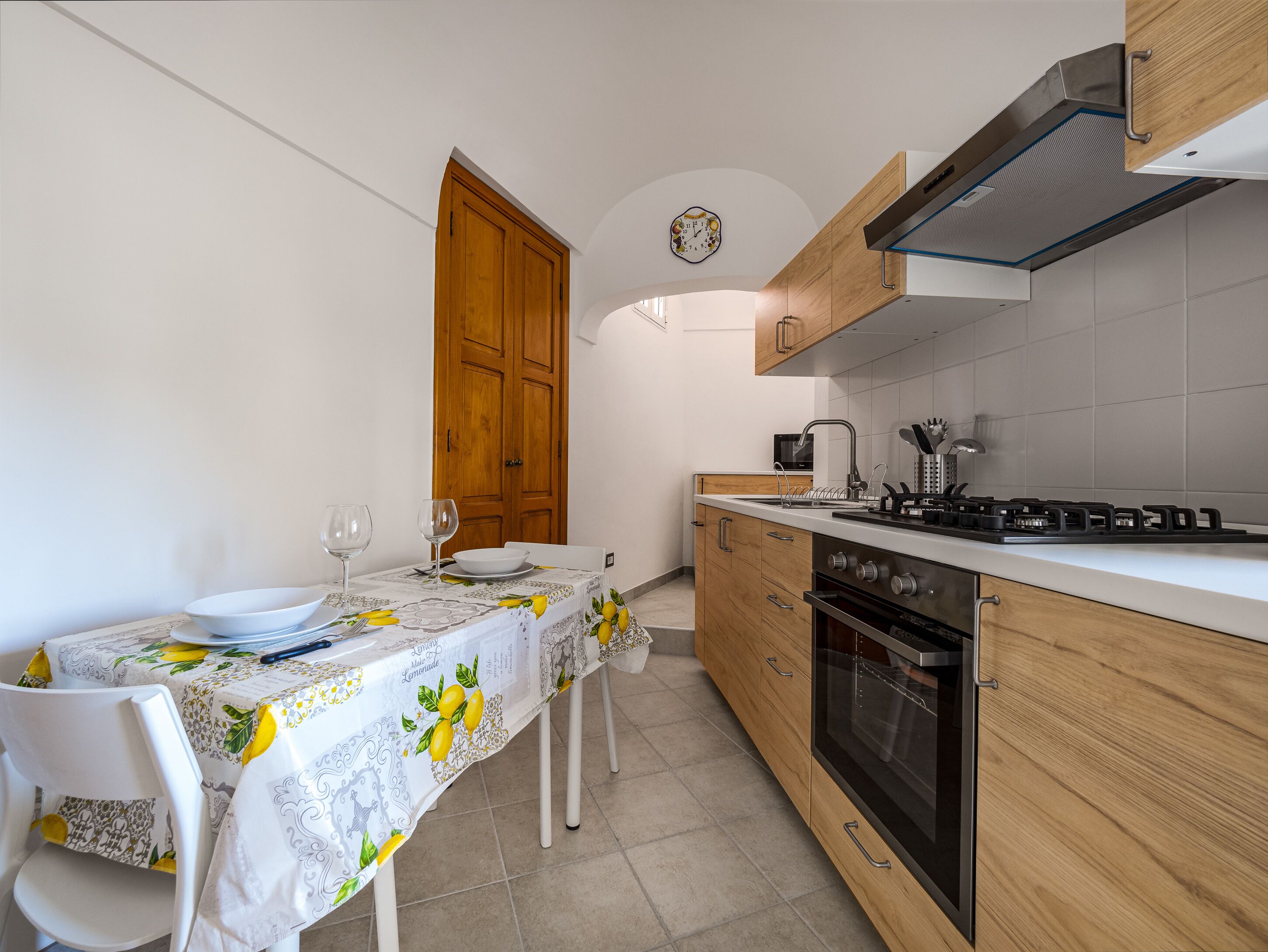 Cocina compacta con una mesa de comedor para dos personas, microondas, estufa y horno.
