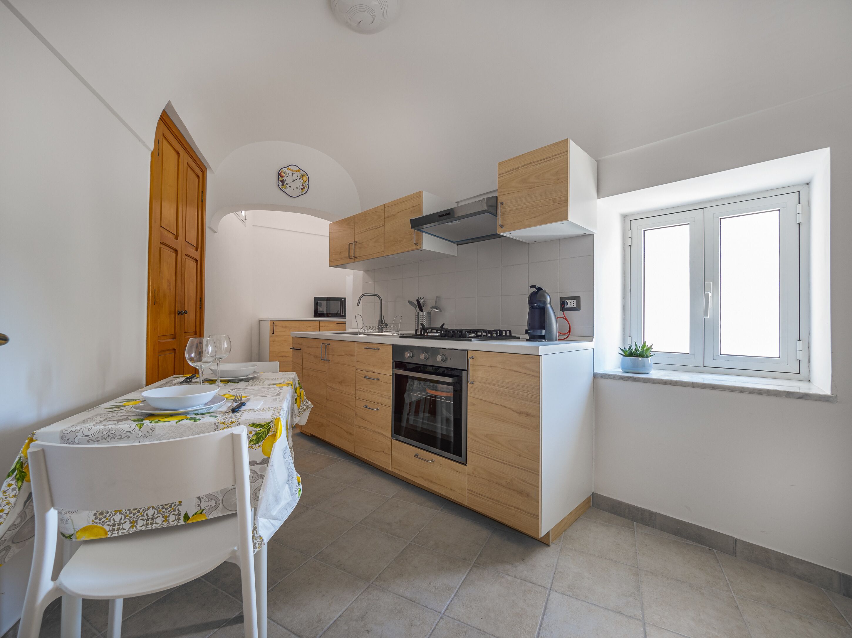 Una cocina moderna con armarios de madera, horno empotrado y ventana.