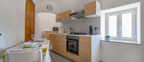 Una cocina moderna con armarios de madera, horno empotrado y ventana.