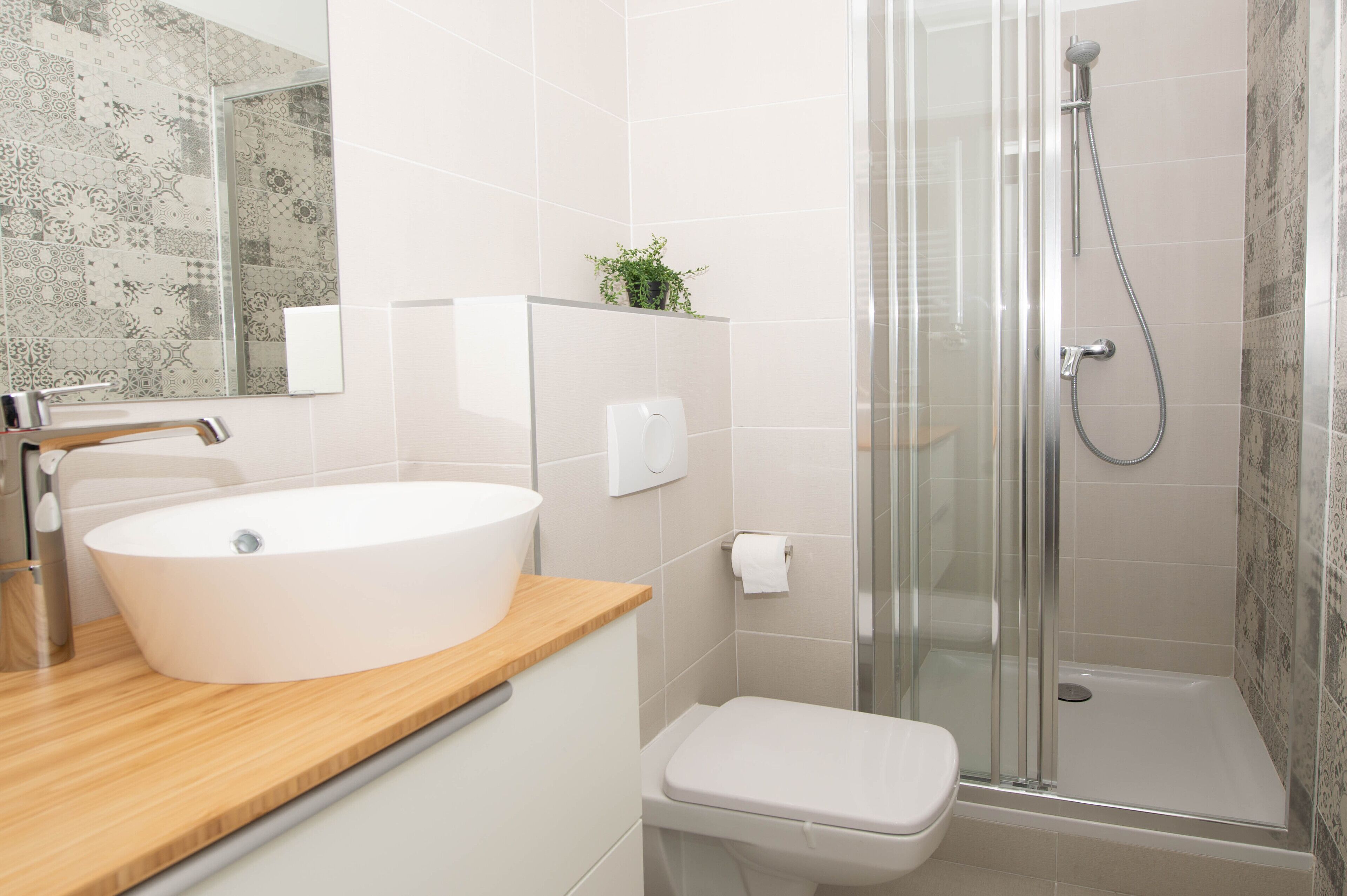 A bathroom with a white sink, a toilet, and a glass-enclosed shower.