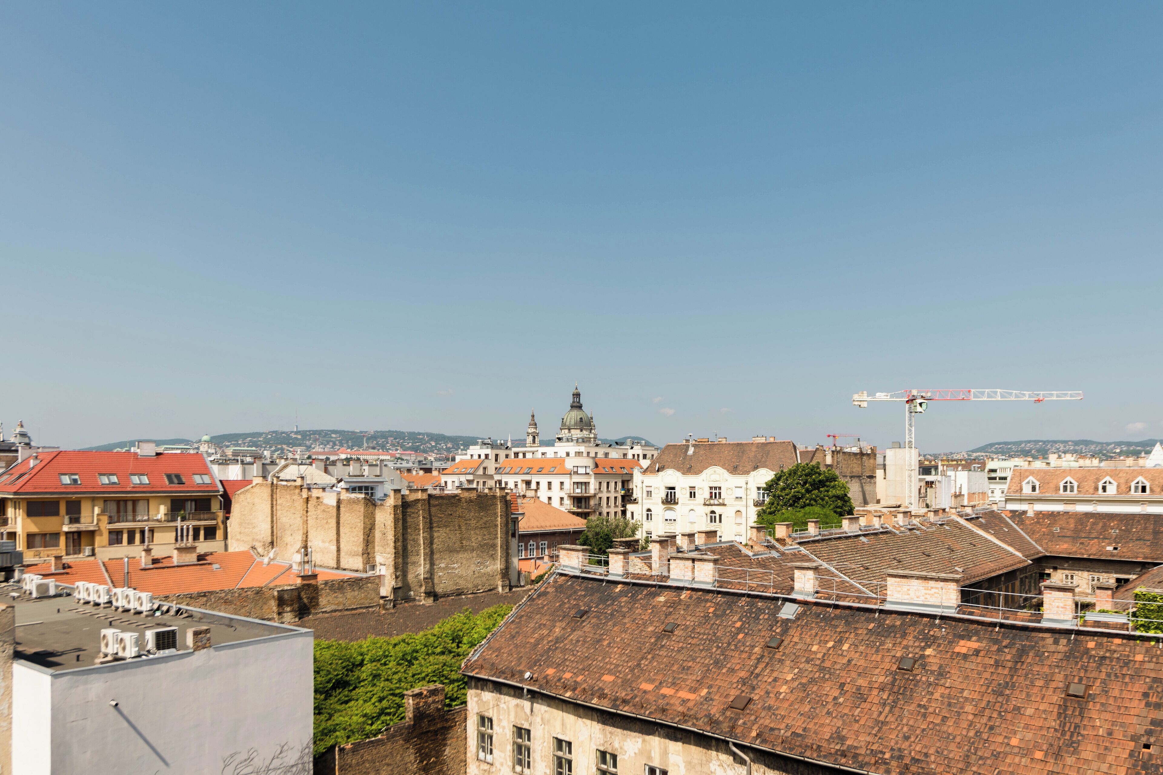 A cityscape with historic buildings, a prominent dome structure, and a construction crane.