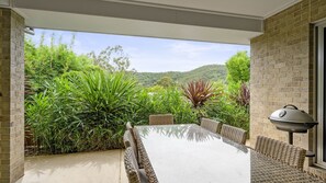 Relax on the patio surrounded by a lush landscape and enjoy a meal at the barbecue grill.