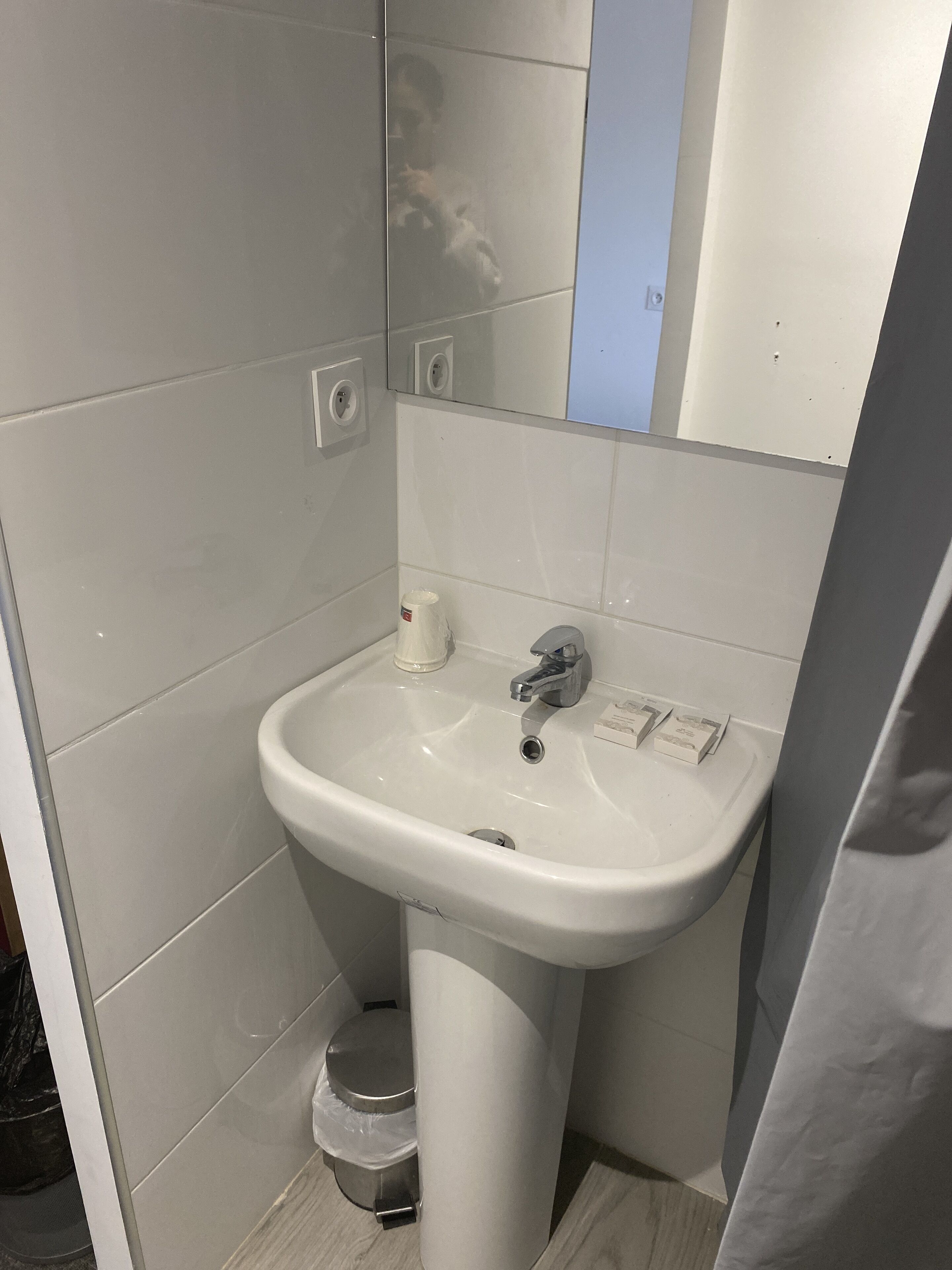 A bathroom with a white sink, a mirror, and a toilet.