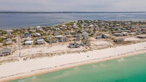 An aerial view of a coastal residential area with houses, a beach, and a clear view of the ocean. - Brand New Heated Pool! Remodeled 3 Bedroom Cottage/Steps to the beach! (Pensacola Beach)