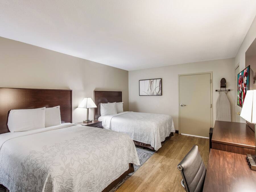 Une chambre d’hôtel avec deux lits, un bureau et une chaise.