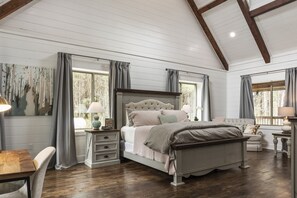 Classic bedroom with a large bed, nightstands, and a comfortable seating area.