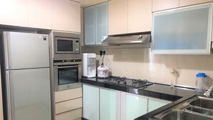 Una cocina moderna con electrodomésticos de acero inoxidable, horno empotrado, microondas, cocina a gas y dispensador de agua.