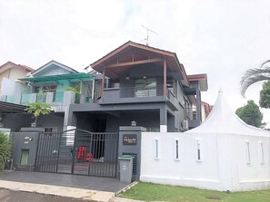 A two-story house with a balcony, a gated entrance, and a white tent-like structure in the front yard. - OYO 90476 Casa Azlinda Muslim Homestay I (Johor Bahru)