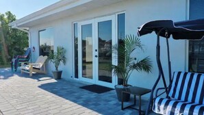 Un espace extérieur aménagé avec une piscine, des chaises longues et des plantes en pot.