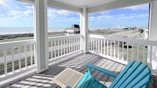 Eine überdachte Veranda mit Blick auf Strand und Meer.